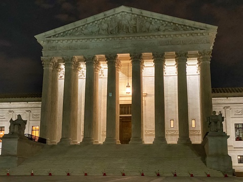 The United States Supreme Court is a  four-story building was designed by Cass Gilbert in a classical style sympathetic to the surrounding buildings of the Capitol and Library of Congress, and is clad in marble.