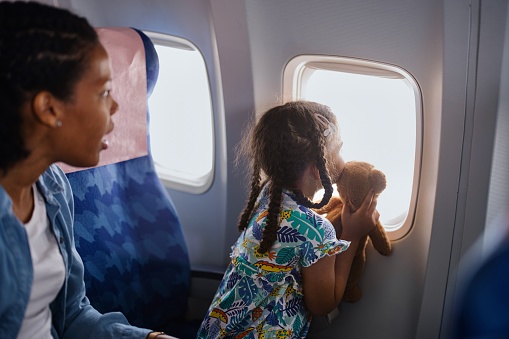 Multiracial family with two children traveling to summer vacation by airplane.