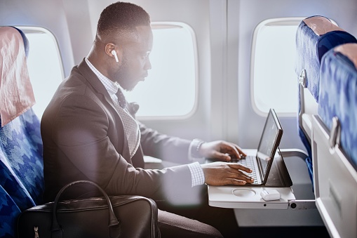 Business person working on digital tablet during flight