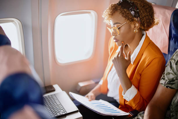 istock Businesswoman reading documents  and working on digital tablet during flight 1401027413