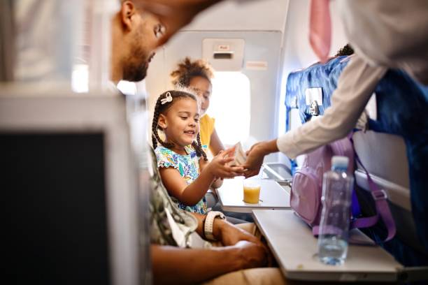 Stewardesses serving food and drinks to family on the airplane during flight Cabin crew pushing service cart and serve to customer on the airplane during flight cabin crew stock pictures, royalty-free photos & images