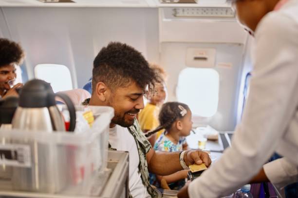 istock Male passenger using credit card to pay stewardess food and drinks he ordered 1401029231