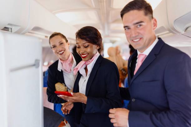 Portrait of a smiling cabin crew members during disembarking Smiling flight attendants looking at camera during disembarking crew stock pictures, royalty-free photos & images