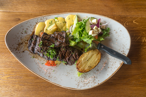A white plate of beef steak with medium rare, served with french fries and salad high resolution stock photo