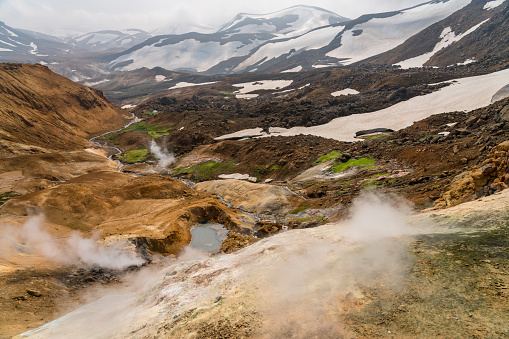 Beautiful landscape of Hveradalir  geothermal area on sunny day, some snow, steam  and  orange rocks, Iceland