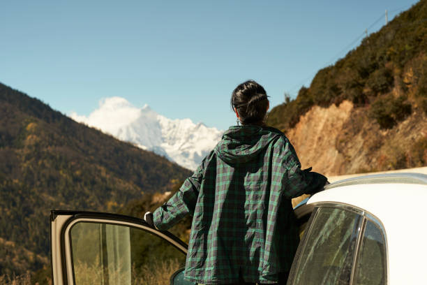 asian woman female tourist looking at snow covered mount kawaboge in yunnan, china rear view of asian woman female tourist looking at snow covered mount kawaboge in yunnan, china, focus on foreground meili mountains photos stock pictures, royalty-free photos & images