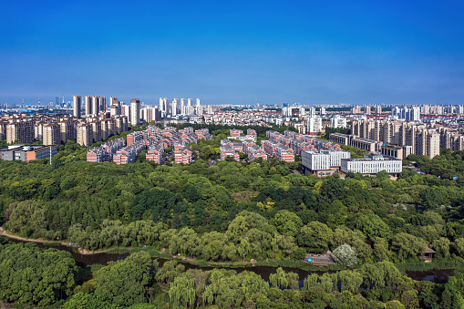 Aerial view of the Wetland Park in the city in Shanghai, China. The wetland park is surrounded by a large area of apartment buildings and business centers in the city