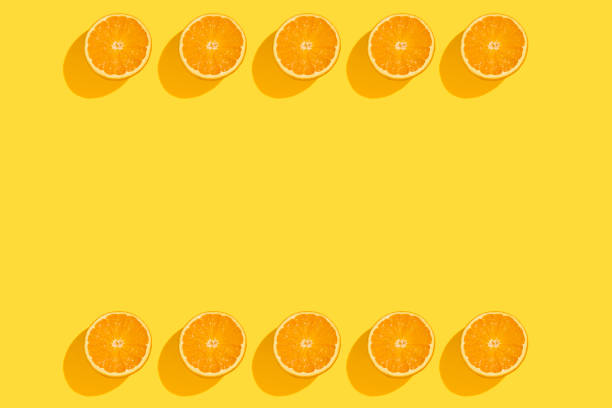 istock Fresh orange halves on yellow background. 1401043684