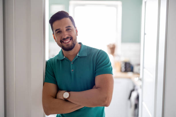 Smiling man standing in the doorway to the kitchen stock photo