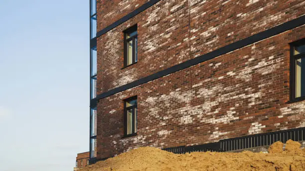 A new brick house stained with white efflorescence, a crystalline of salt, formed due to water being present in the bricks. Construction defects