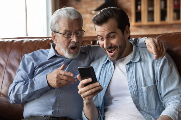 istock Overjoyed surprised two generations of men looking at phone screen 1401046589