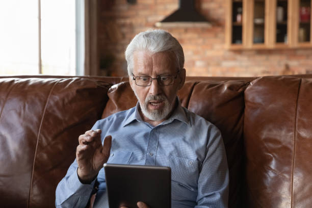 istock Overjoyed shocked mature man in glasses looking at tablet screen 1401046594