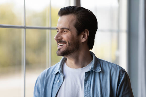 istock Head shot smiling dreamy man looking in distance, dreaming 1401046599