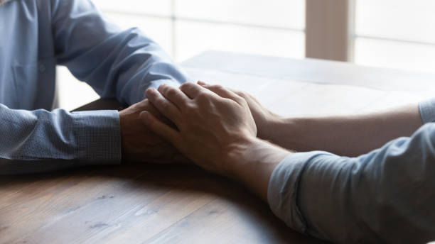 istock Crop close up caring grownup son holding mature father hands 1401046603
