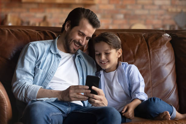 istock Happy father and little son having fun with smartphone 1401046612