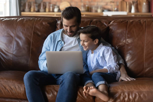 istock Caring father with little son hugging, using laptop together 1401046614