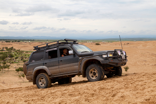 Elsen Tasarkhai, Mongolia - August 04 2018: Mongolian driving a Toyota Land Cruiser on a dune of \