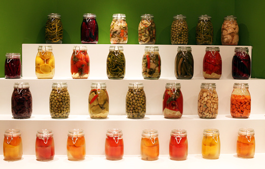 Pickles (Turkish: Tursu) in glass jars on delicatessen shelves.