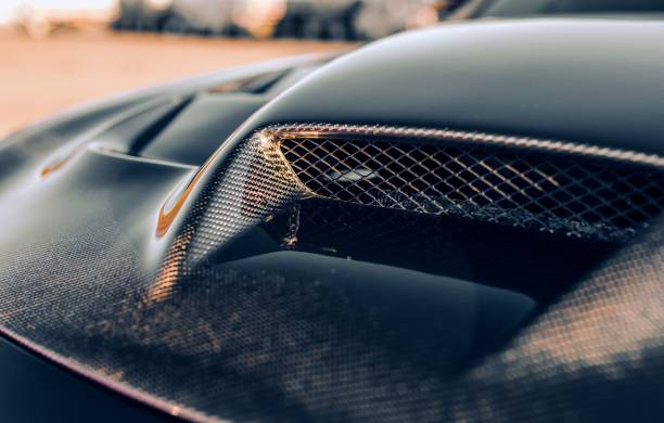 Aftermarket carbon fiber hood on a muscle car with a large hood scoop