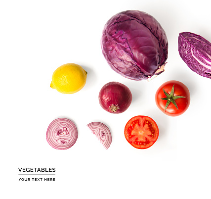 Creative layout made of red cabbage, onion, tomatoes and lemon. Flat lay. Food concept. Vegetables isolated on white background.