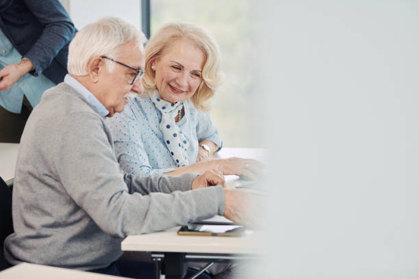 istock Seniors sit in a classroom and talking about project on the laptop. 1401054936