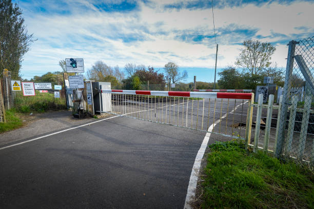 railroad crossing with barriers down on country road near canterbury, kent, england. - railroad crossing railway signal gate nobody imagens e fotografias de stock