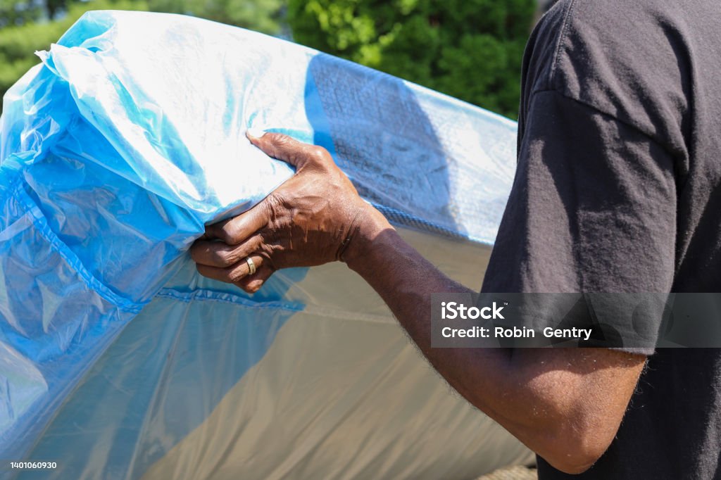 A black African-American man delivering a new mattress Mattress Stock Photo