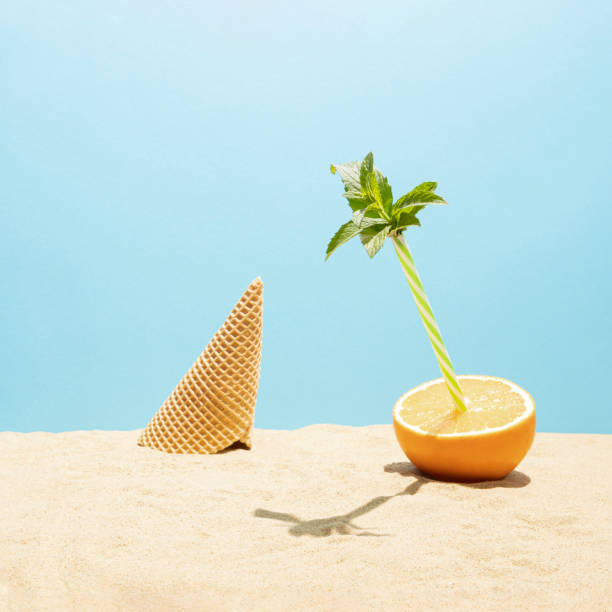 scène de vacances d’été tropicales avec orange frais, feuilles de menthe et cône de vream de glace sur le sable de la plage. concept d’aliment juteux minimal. - grapefruit citrus fruit water fruit photos et images de collection