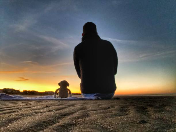 Sunrise Over Edisto Island A man and his sock monkey take in the sunrise over Edisto Island, South Carolina. edisto island south carolina stock pictures, royalty-free photos & images