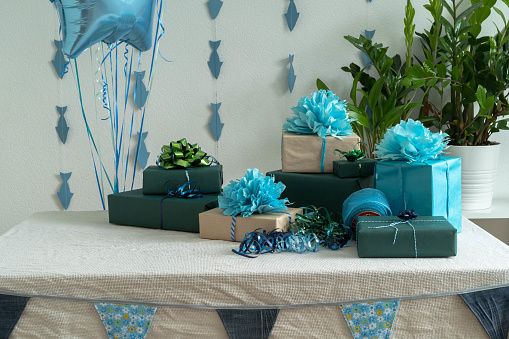 Blue gel balls and gift boxes and flags on the table . The concept of a birthday, wedding or Christmas or holiday. Horizontal photo.