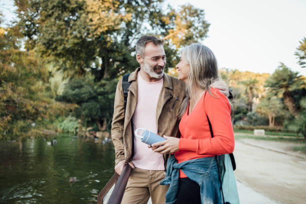 Happy mature couple enjoying their vacation and taking a break by the river stock photo