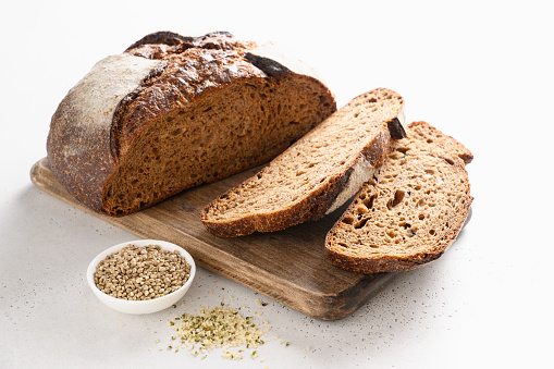 Loaf of Hemp bread, hempseeds and flour isolated on white background. Close up.