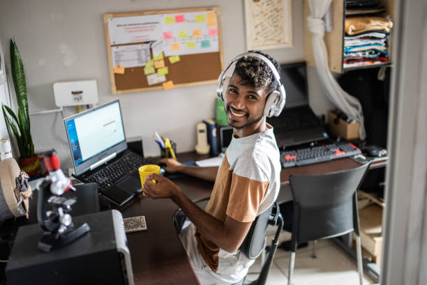 istock Portrait of a young man using laptop working or studying at home 1401068817