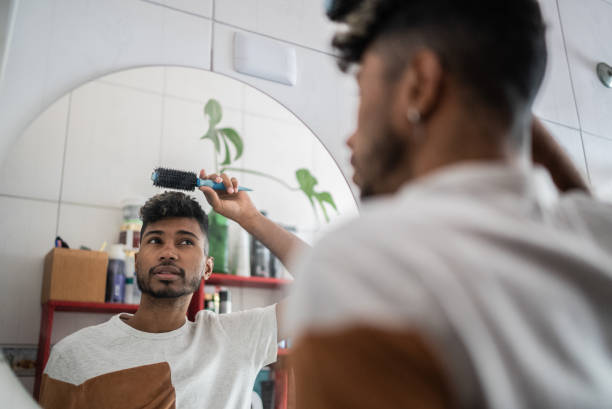 istock Young man brushing hair with comb at bathroom 1401068827