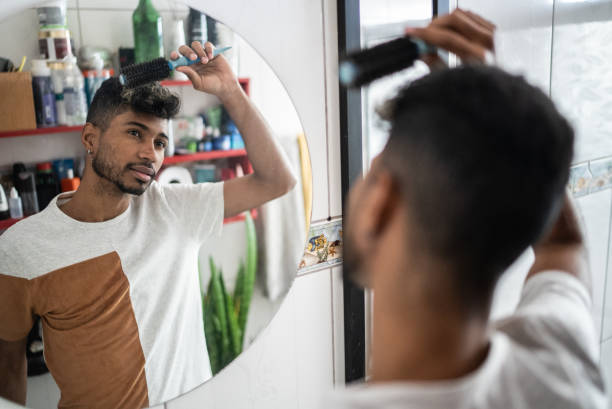istock Young man brushing hair with comb at bathroom 1401068828