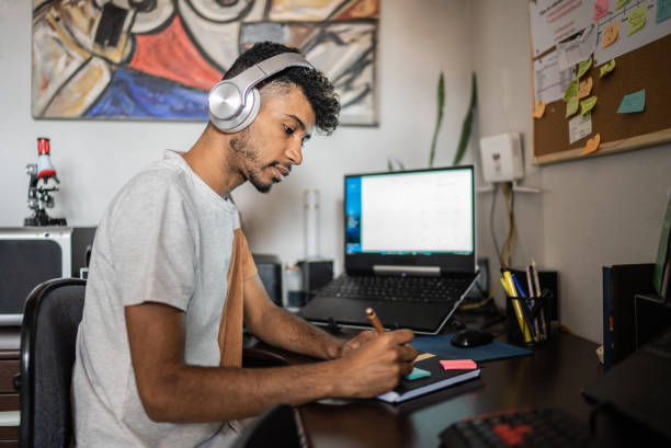istock Young man writing on sticky note at home 1401068835