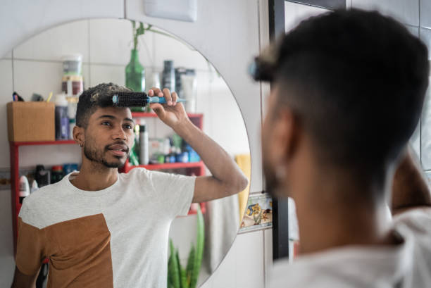 istock Young man brushing hair with comb at bathroom 1401069114