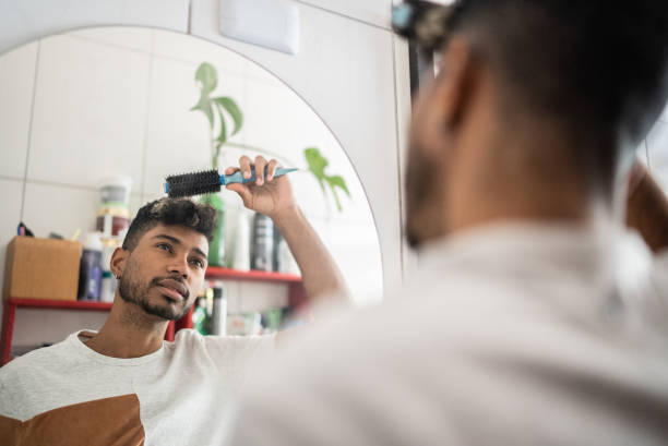 istock Young man brushing hair with comb at bathroom 1401069352