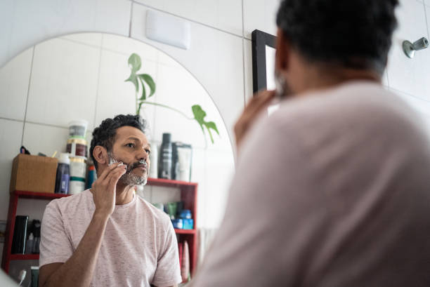 dojrzały mężczyzna nakładający piankę do golenia na twarz - men shaving human face bathroom zdjęcia i obrazy z banku zdjęć