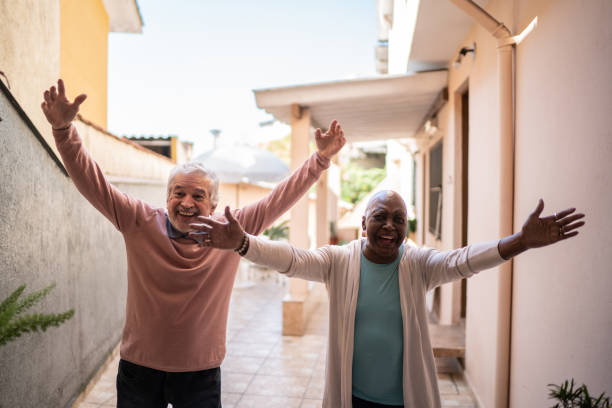 starsza para wita kogoś w domu - arms outstretched greeting house women zdjęcia i obrazy z banku zdjęć