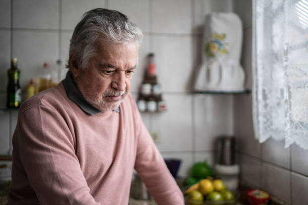 uomo anziano che sente dolore a casa - men senior adult serious depression foto e immagini stock