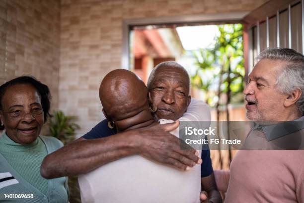 Senior friends greeting each other at home
