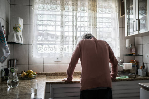 hombre mayor sintiendo dolor en casa - soledad fotografías e imágenes de stock