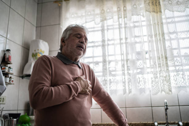 un homme âgé ressent de la douleur à la maison - strangling photos et images de collection