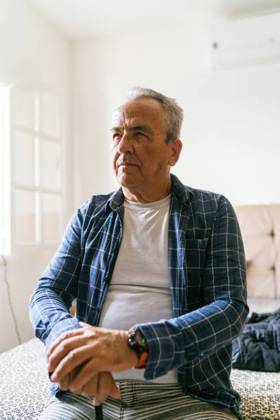 istock Elderly man sitting on bed 1401071116