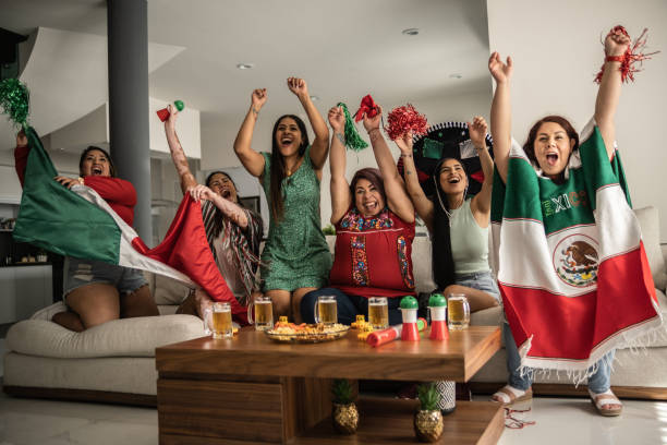 друзья празднуют гол мексиканской футбольной команды дома - latin america mexican flag mexico mexican culture стоковые фото и изображения