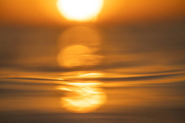 Shallow depth of field scene of sun setting over the ocean surface