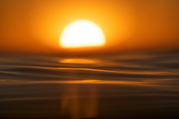 istock Shallow depth of field scene of sun setting over the ocean surface 1401072071