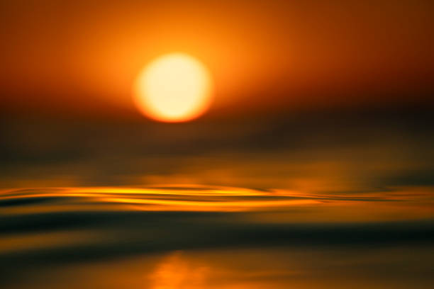 istock Shallow depth of field scene of sun setting over the ocean surface 1401072104