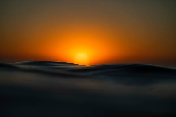 istock Shallow depth of field scene of sun setting over the ocean surface 1401072684